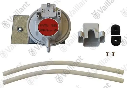 Vaillant Druckwächter mit mehreren Anschlussmöglichkeiten, montiert auf einer Metallplatte, begleitet von zwei Schläuchen und Zubehörteilen.